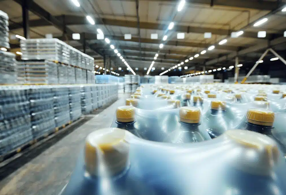 Beverage bottles moving through automated warehouse distribution facility conveyor system