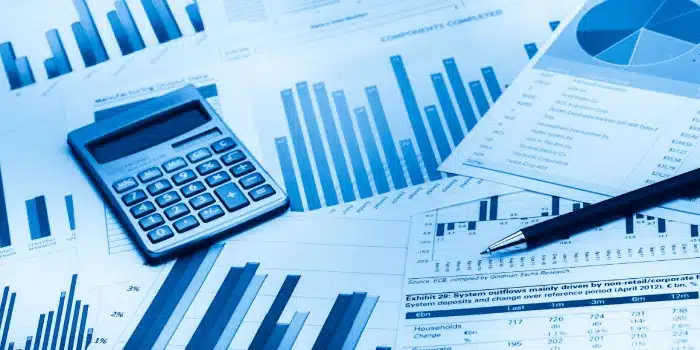 Financial charts, calculator and pen for 3PL WMS software performance analysis