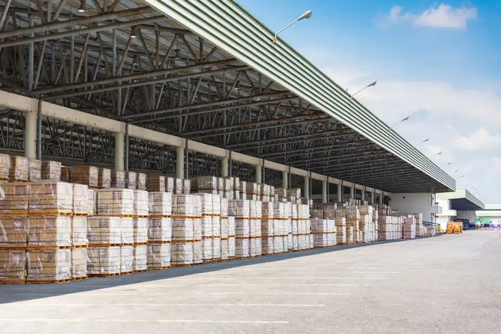 Large warehouse facility with organized palletized goods under modern industrial roof structure