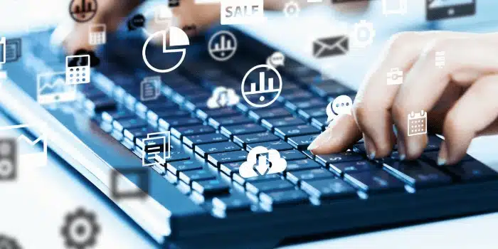 Hands typing on laptop keyboard with digital WMS software icons and analytics charts