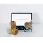 Laptop with cardboard shipping boxes representing warehouse management and peak season preparation
