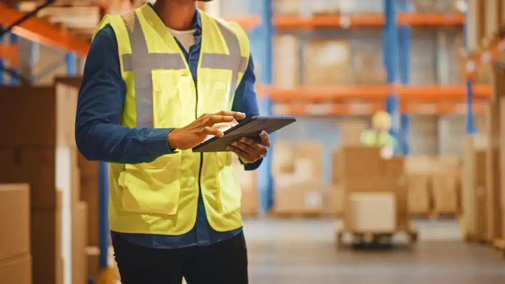Warehouse worker using tablet for inventory management in distribution center