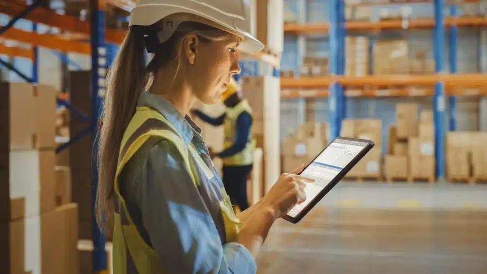 Female warehouse worker using tablet for inventory management in distribution center