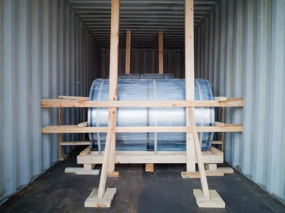 Wooden dunnage framework securing wrapped cargo inside shipping container for transport protection