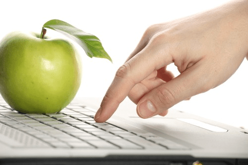 typing on a laptop with an apple