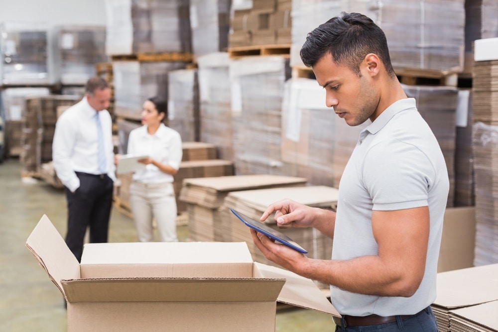 male manager using digital tablet in warehouse