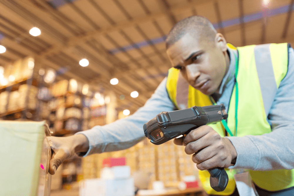warehouse worker scanning a box with an RF scanner for picking