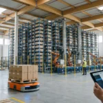 Wide-angle view of a modern warehouse using optimization software, featuring automated systems and workers with tablets.